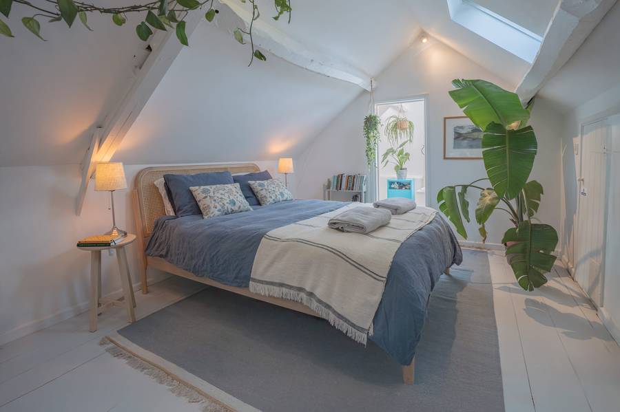 Bright bedroom interior with painted floorboards in a Cotswold home