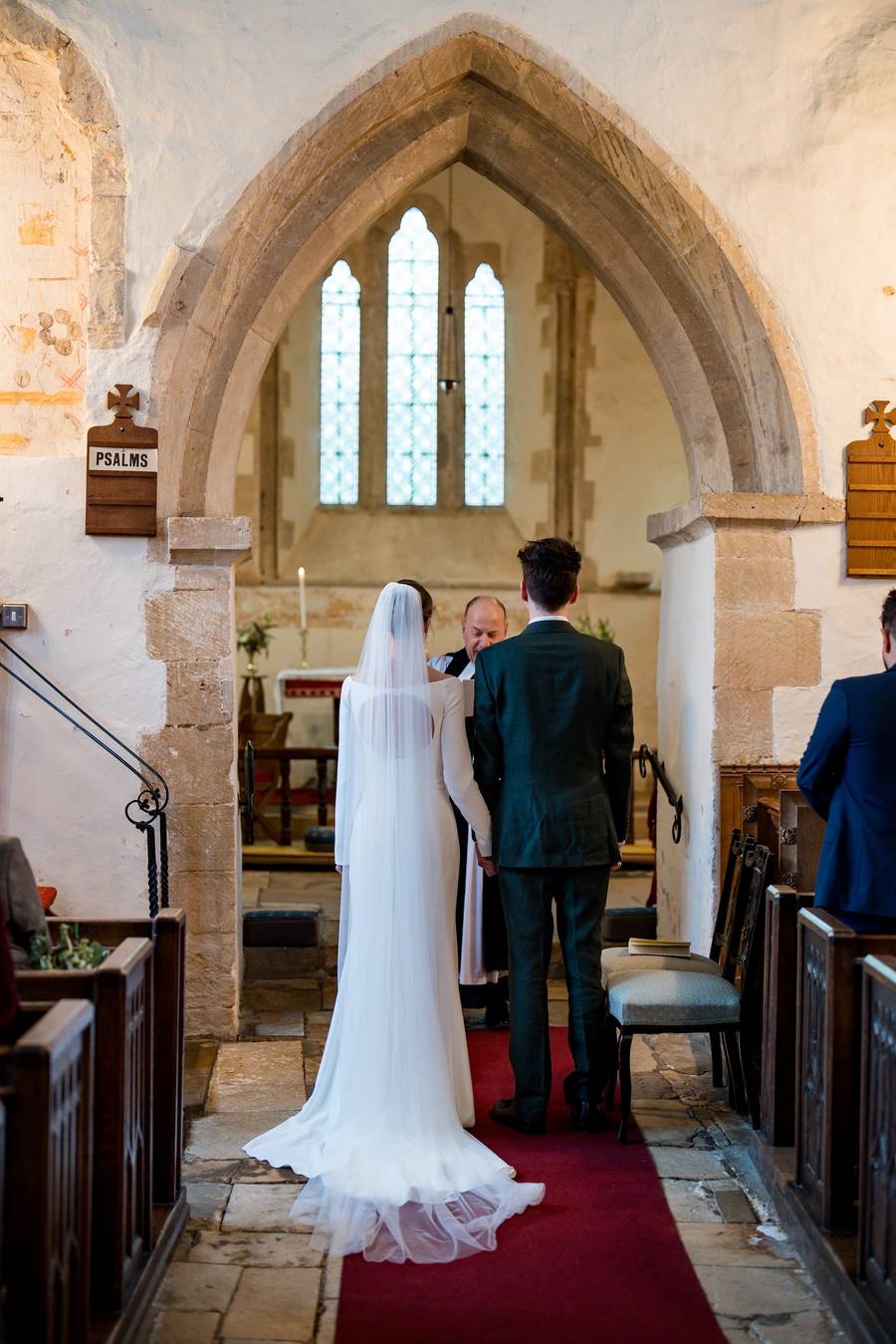 Bride and groom at the altar of Bledington church, Cotswolds