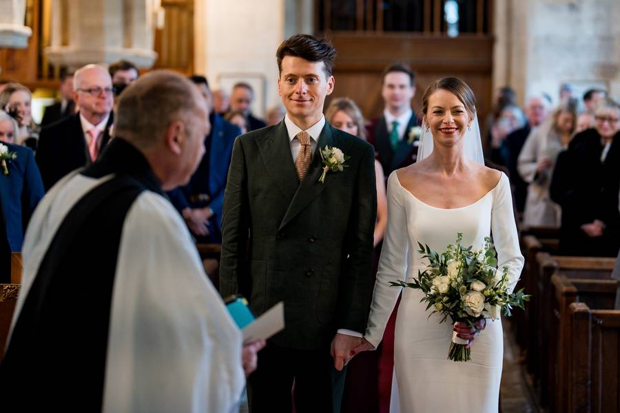Bride and groom walking down the aisle at Bledington church