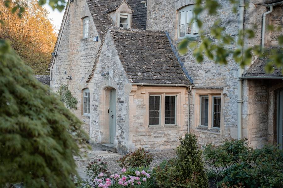 Historic stone barn gateway at Swinbrook Manor Farm at dusk
