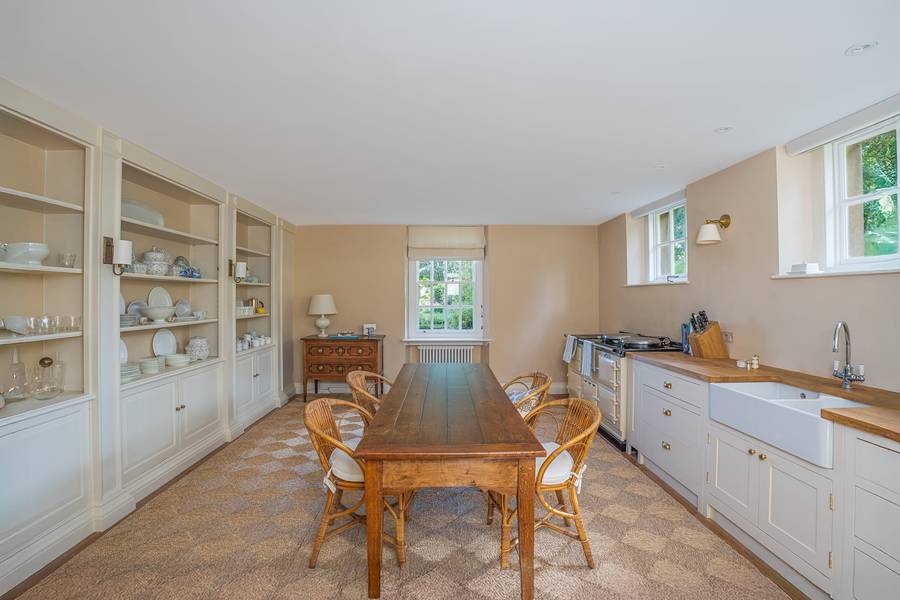 Farmhouse kitchen with oak table and Aga in a Cotswold manor